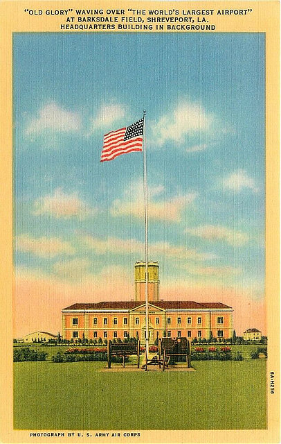 "Old Glory" waving over "The World's Largest Airport", at Barksdale Field, with the base headquarters building in the background